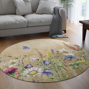 May include: A round rug with a beige background featuring a watercolour design of various flowers and greenery. The flowers are in shades of pink, purple, white, and yellow.