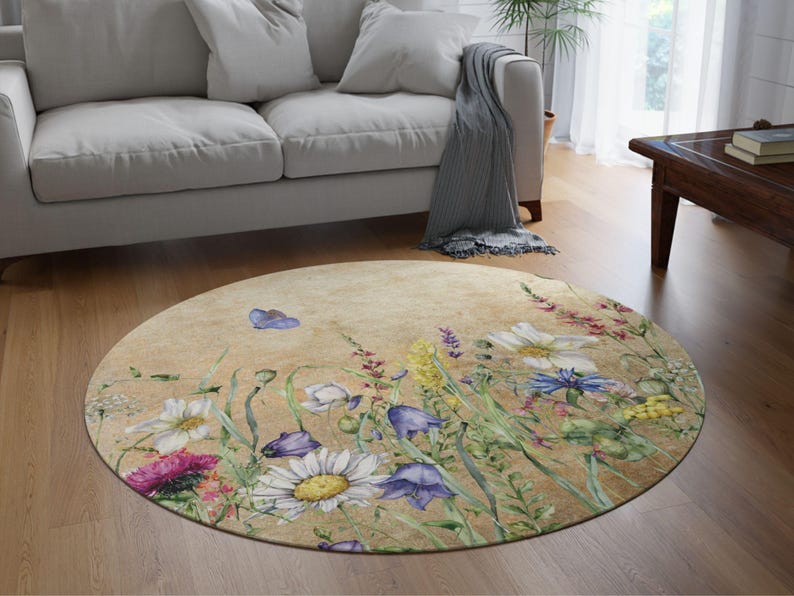 May include: A round rug with a beige background featuring a watercolour design of various flowers and greenery. The flowers are in shades of pink, purple, white, and yellow.