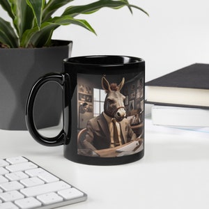 Può includere: Tazza in ceramica nera con un'immagine bianca di un asino che indossa un abito e una cravatta, seduto a una scrivania in un ufficio.