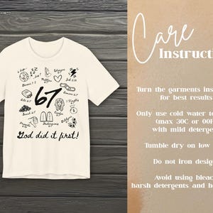 May include: Cream-colored t-shirt with black graphic illustrations and the text "67 God did it first!". The shirt features various small drawings and the words "Care Instructions" on the right side.