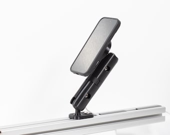 May include: A black phone is mounted on a black and silver adjustable bracket. The phone is angled, and the bracket is attached to a silver rail. The background is plain white.