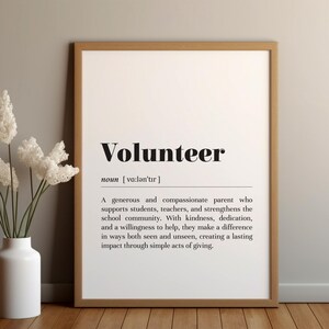 May include: A framed print with the word "Volunteer" in bold black letters. The definition of volunteer is printed below the word. A white vase with white flowers is to the left of the framed print.