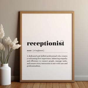 Könnte beinhalten: Ein gerahmter Druck mit dem Wort "receptionist" in schwarzer Schrift und der Definition darunter. Links befindet sich eine weiße Vase mit weißen Blumen. Der Rahmen ist braun.