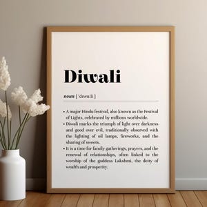 Puede incluir: Un cartel enmarcado con la palabra "Diwali" en negrita negra. Debajo, la definición de Diwali, una importante fiesta hindú, también conocida como el Festival de las Luces. Un jarrón blanco con flores blancas está en primer plano.