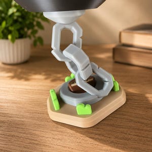 May include: A light gray plastic chain link structure extending upward from a tan base. The base features small bright green accents and a central brown circular element. The chain connects to a dark gray rounded object at the top of the assembly.