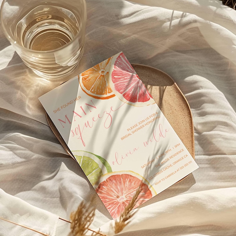 May include: A bridal shower invitation with watercolor citrus fruit illustrations. The invitation features the text "She found her Main Squeeze" and details for the event, including the date, time, and location.
