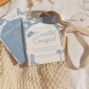 May include: Two light blue and white invitation cards with a coastal theme. One card reads "Weekend Details" and the other says "Coastal Cowgirl" with event details. The cards feature illustrations of seashells, cowboy boots, and hats.