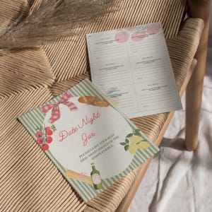 K&ouml;nnte beinhalten: Ein Date Night Jar-Kit mit gr&uuml;n-wei&szlig;em Streifendesign. Der Deckel des Glases zeigt Illustrationen von Tomaten, Zitronen, Nudeln, einem Baguette und einer Weinflasche. Der Text lautet "Date Night Jar" und "Bitte hinterlassen Sie Ihre besten Date-Night-Ideen f&uuml;r das gl&uuml;ckliche Paar."