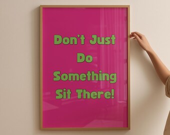 May include: A framed poster with a bright pink background and green text that reads "Don't Just Do Something Sit There!". The frame is a light brown color.