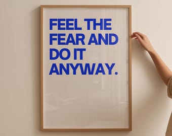 May include: A framed print with the text "FEEL THE FEAR AND DO IT ANYWAY." in blue lettering on a white background.