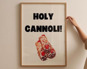May include: Framed art print featuring the text "HOLY CANNOLI!" in bold black letters above a watercolor illustration of two cannoli pastries. The cannoli have red cherries and chocolate sprinkles.