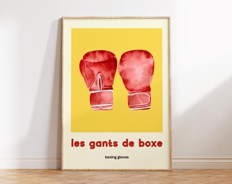 May include: Framed art print featuring two red boxing gloves on a yellow background. The text "les gants de boxe" is in red, with "boxing gloves" below. The artwork is in a wooden frame.