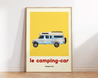 May include: A framed print featuring a light blue camper van illustration against a yellow background. The text "le camping-car" is in red, with "camper van" below. The artwork is in a wooden frame.