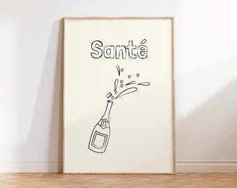 May include: A framed print featuring a black and white illustration of a champagne bottle with the word "Santé" above it. The bottle is depicted with bubbles and spray, suggesting a celebratory theme.