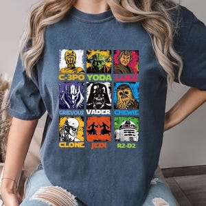 May include: Denim blue t-shirt with a grid of Star Wars characters: C-3PO, Yoda, Luke, Grievous, Darth Vader, Chewie, Clone, Jedi, and R2-D2. The word "DENIM" is visible on the bottom right.