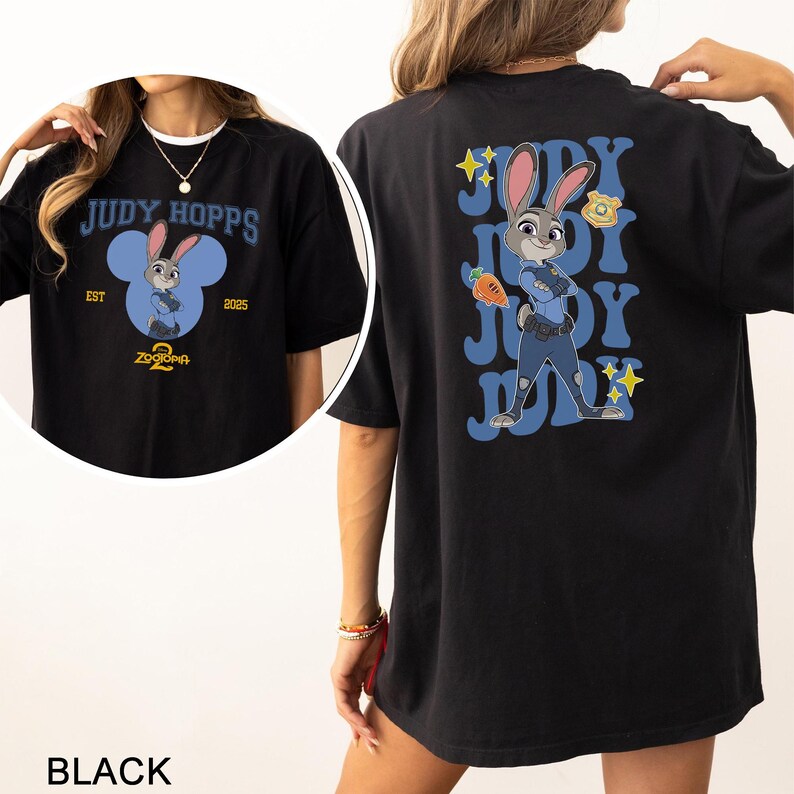 May include: Black t-shirt featuring Judy Hopps from Zootopia. The front design includes the text "JUDY HOPPS" above a cartoon image of Judy Hopps inside a blue Mickey Mouse-shaped design. The back features Judy Hopps in a police uniform.