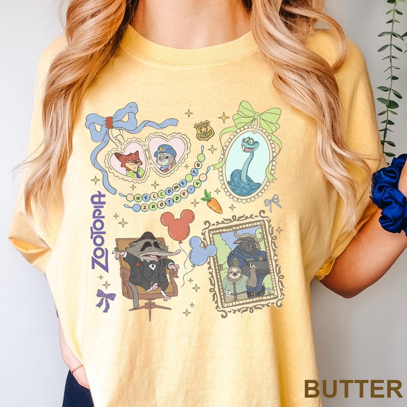 Puede incluir: Camiseta amarilla mantequilla con un dise&ntilde;o gr&aacute;fico colorido con personajes y elementos de la pel&iacute;cula "Zootopia". El dise&ntilde;o incluye im&aacute;genes enmarcadas, personajes de dibujos animados y la palabra "Zootopia".