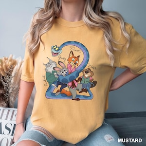 K&ouml;nnte beinhalten: Senffarbenes T-Shirt mit einem Cartoon-Motiv von Filmfiguren. Das Design zeigt eine blaue Schlange, die sich um die Zahl 2 windet, mit Tierfiguren und Namen wie Judy und Nick. Das Wort "MUSTARD" steht unten.