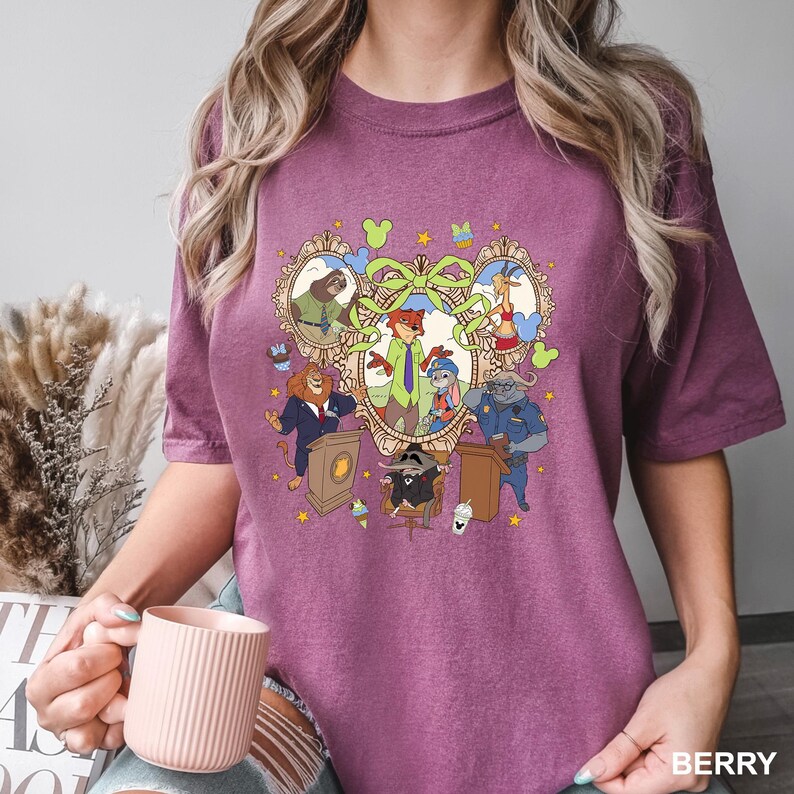 May include: Berry-colored t-shirt featuring a cartoon graphic of various animal characters in a decorative frame. The design includes a fox, bunny, lion, and other animals. The word "BERRY" is printed at the bottom right.