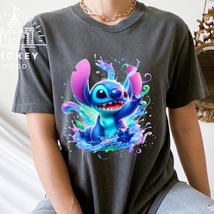 a woman sitting on a bed wearing a t - shirt with a stitching stitch