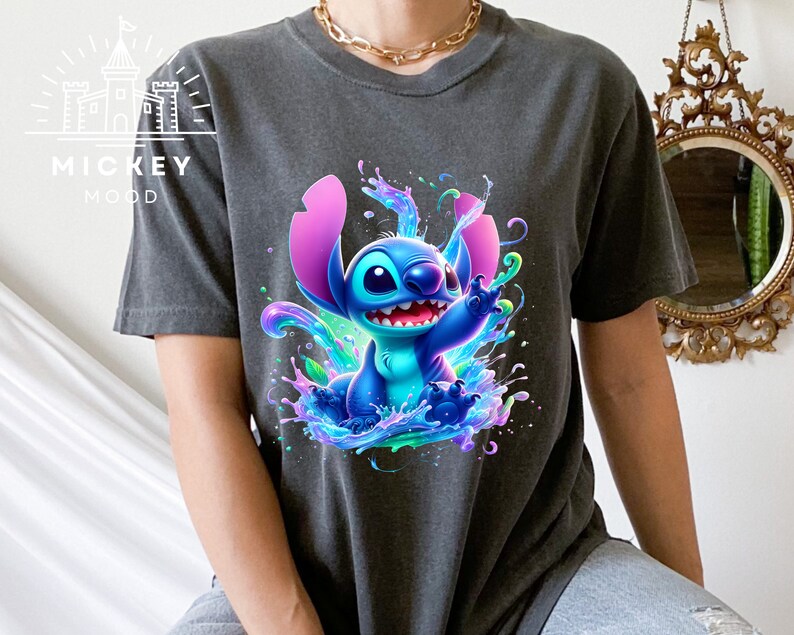 a woman sitting on a bed wearing a t - shirt with a stitching stitch