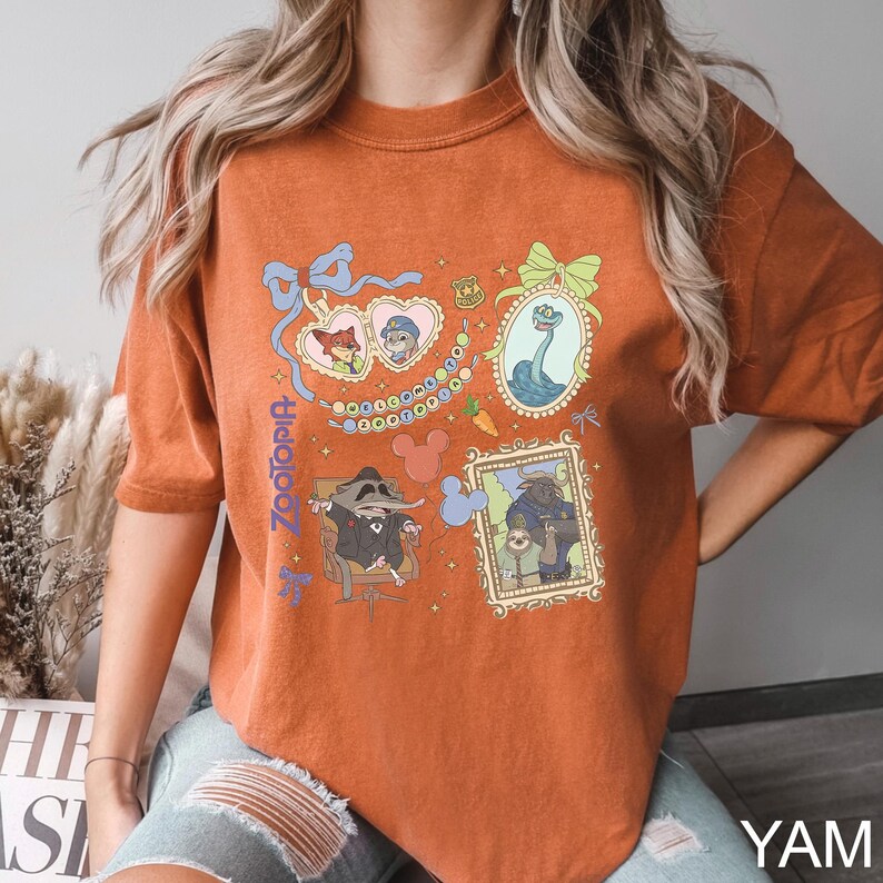 Puede incluir: Camiseta naranja quemado con ilustraciones enmarcadas de personajes de la pel&iacute;cula animada Zootopia. La camiseta incluye el t&iacute;tulo de la pel&iacute;cula en una fuente estilizada. Las ilustraciones est&aacute;n en marcos ornamentados con un estilo de dibujos animados.
