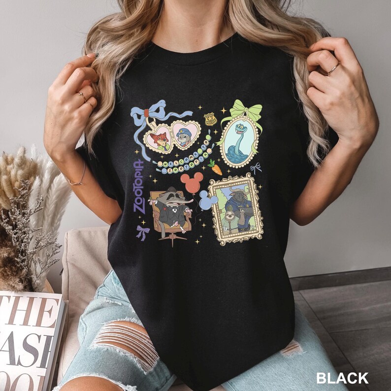Puede incluir: Camiseta negra con ilustraciones coloridas de la pel&iacute;cula Zootopia. El dise&ntilde;o incluye retratos de personajes enmarcados, una cabeza de Mickey Mouse y la palabra "Zootopia" en escritura vertical. La camiseta es de cuello redondo.