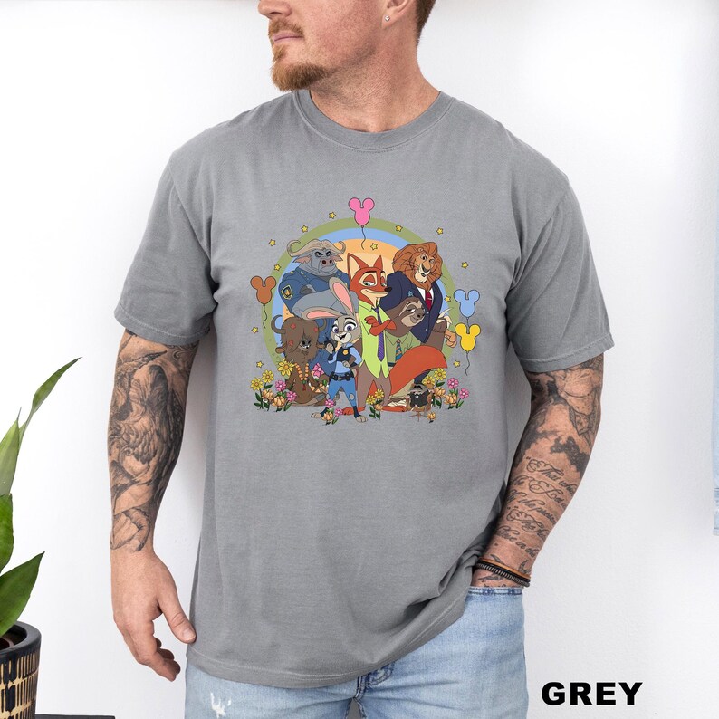 May include: Grey t-shirt featuring a colorful cartoon illustration of characters from Zootopia, including Judy Hopps, Nick Wilde, and others. The design is surrounded by flowers and balloons. The word "GREY" is printed at the bottom.