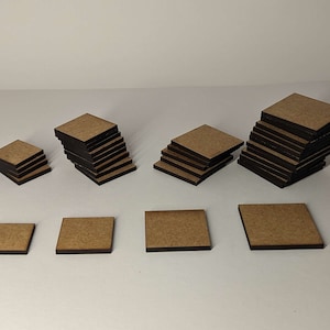 May include: A set of seven wooden square coasters in various sizes. The coasters are stacked in different heights and are made of natural wood with a dark brown stain.