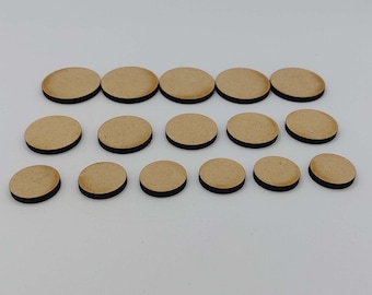 May include: A set of 14 round wooden bases for miniature figures. The bases are various sizes and have a black edge.