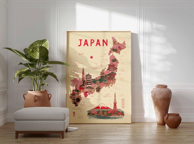 May include: A framed poster with the word "JAPAN" in red at the top. The poster features a map of Japan with illustrations of landmarks in red and pink. A large potted plant, a gray ottoman, and decorative vases are in front of a white wall.