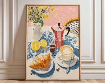 Könnte beinhalten: Gerahmter Kunstdruck, der eine Frühstücksszene darstellt. Eine rosa Kaffeemaschine, eine Tasse Kaffee, ein Croissant und Zitronenscheiben sind auf einem Tisch angeordnet. Eine Vase mit gelben Blumen und ein blau-weißes Tuch vervollständigen die Komposition.
