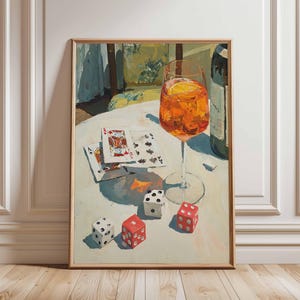 May include: A framed painting depicts a still life with a cocktail in a stemmed glass, playing cards, dice, and a bottle. The drink is orange with a slice of citrus. The dice are red and white. The cards are fanned out on a white surface.