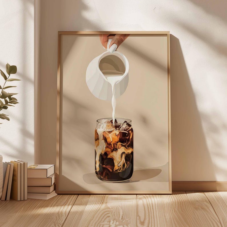 May include: A framed art print depicts a refreshing iced coffee. A white pitcher pours milk into a glass filled with ice and coffee. The artwork has a neutral color palette with a beige background and a wooden frame.
