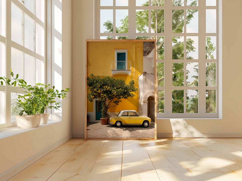 May include: A framed print of a yellow building with a teal balcony and a yellow car parked in front. A tree with yellow fruit is in front of the building. The print is in a room with a window and plants.