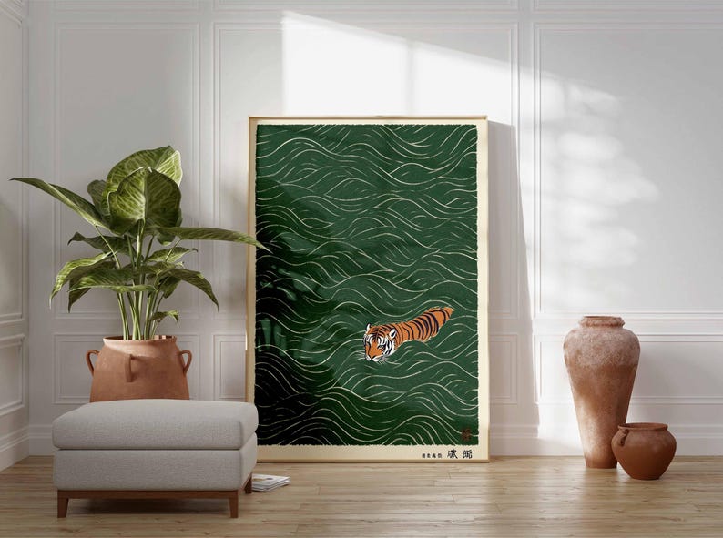 May include: A framed art print featuring a tiger swimming in green water with white wave patterns. The tiger has orange and black stripes. The artwork is in a gold frame and has Japanese text in the lower right corner.