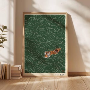 May include: A framed art print featuring a tiger swimming in green water with white wave patterns. The tiger has orange and black stripes. The artwork has Japanese text in the lower right corner.