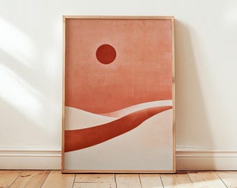Puede incluir: Una impresión de arte mural rectangular en un marco de madera clara con una ilustración de paisaje desértico. La obra muestra un círculo rojo oscuro sólido que representa el sol sobre dunas de arena fluidas en tonos terracota y crema.