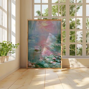 May include: A framed artwork depicts a serene water scene with swans, lily pads, and soft pink and blue hues. The artwork is displayed in a well-lit room with a large window and potted plants.
