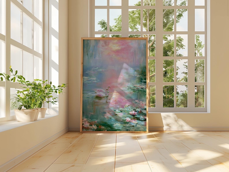 May include: A framed artwork depicts a serene water scene with swans, lily pads, and soft pink and blue hues. The artwork is displayed in a well-lit room with a large window and potted plants.