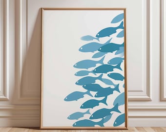 Puede incluir: Una impresión artística enmarcada que presenta un grupo de peces azules nadando hacia la derecha sobre un fondo blanco. Los peces varían en tonos de azul, creando una sensación de profundidad y movimiento. El marco es de color marrón claro.