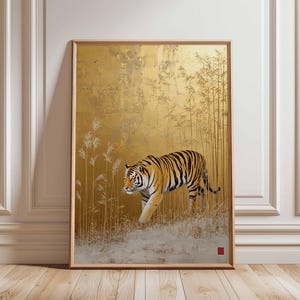 K&ouml;nnte beinhalten: Gerahmtes Kunstwerk mit einem Tiger mit orangefarbenen und schwarzen Streifen, der durch ein Feld mit hohem Gras geht. Der Hintergrund ist goldfarben strukturiert mit Bambusst&auml;ngeln. Das Kunstwerk befindet sich in einem Holzrahmen.