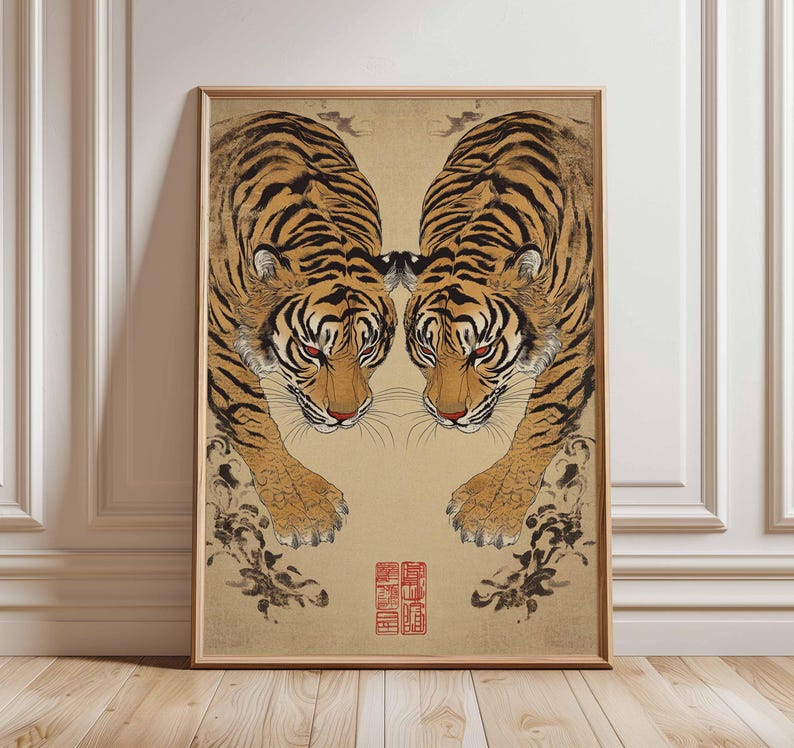 May include: Framed artwork featuring two tigers facing each other. The tigers have orange and black stripes, red eyes, and are set against a beige background. The artwork has a traditional Asian art style with a red seal.
