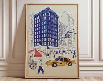 May include: A framed art print depicting a New York City street scene. A tall blue building dominates the center, with a yellow taxi cab and a red and white food cart in the foreground. People are walking on the sidewalk.
