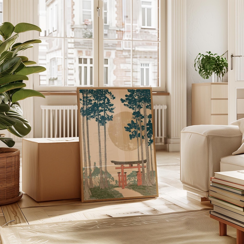 May include: A framed print featuring a Japanese landscape with a large sun, tall trees, and a red torii gate. The artwork has a vintage aesthetic with a beige background and teal and red accents. The print is displayed in a bright, airy room.