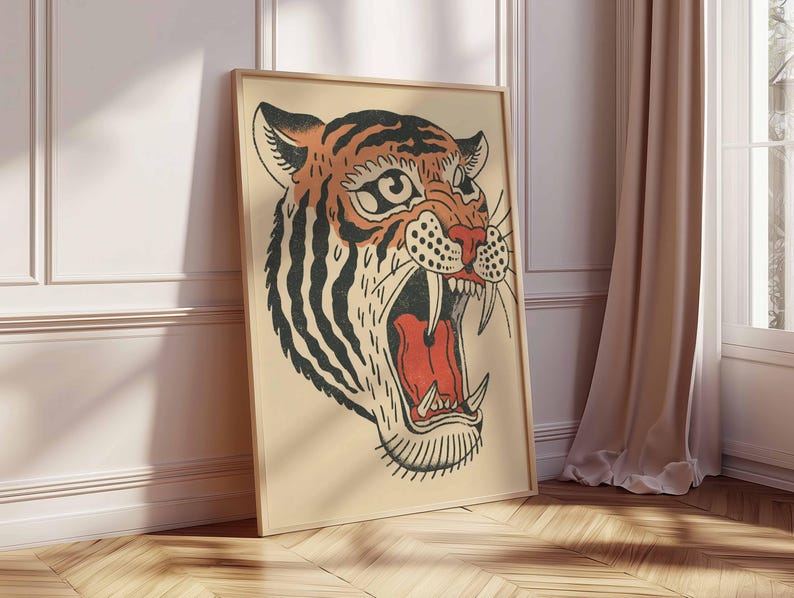 May include: Framed art print featuring a tiger's head with an open mouth, showcasing sharp teeth and a red interior. The tiger has orange and black stripes, with a beige background. The artwork is in a wooden frame, leaning against a wall.