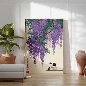 May include: A framed print featuring a Japanese-style illustration of wisteria blossoms in shades of purple and green. The artwork depicts a child reading with birds and butterflies. The scene is set against a cream-colored background.