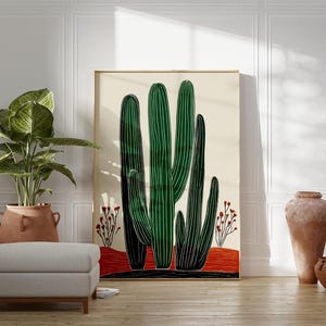 May include: A large framed art print featuring a stylized illustration of green cacti against a cream background. The artwork includes red and black accents, and is displayed in a room with a potted plant, ottoman, and decorative pottery.