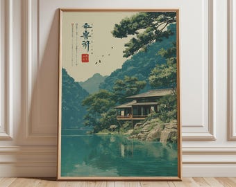 Può includere: Stampa artistica incorniciata di un paesaggio giapponese. L'opera raffigura una casa tradizionale vicino a un lago, circondata da lussureggianti alberi verdi e montagne. La tavolozza dei colori include sfumature di verde acqua, verde e marrone, con testo giapponese in alto a sinistra.
