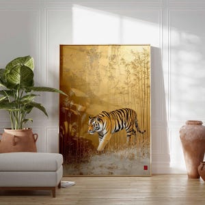 K&ouml;nnte beinhalten: Ein gro&szlig;es gerahmtes Kunstwerk zeigt einen Tiger, der durch einen goldenen Bambuswald geht. Der Tiger hat orange und schwarze Streifen. Das Kunstwerk wird in einem Raum mit einer Pflanze, einem Hocker und dekorativen Vasen ausgestellt.